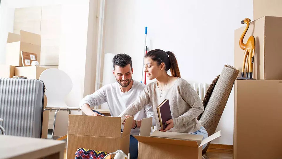 Rental couple unpacking boxes in an apartment.