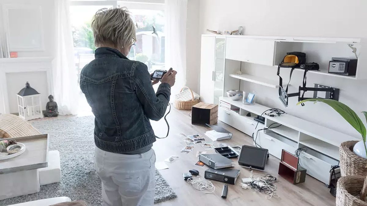 Woman taking pictures after a burglary.